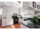 Bright kitchen with white cabinets, black appliances, and granite countertops at 462 Sweetwater Way, Haines City, FL 33844
