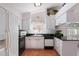 Bright kitchen features white cabinets, black appliances, and granite countertops at 462 Sweetwater Way, Haines City, FL 33844