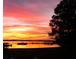 Beautiful sunset view over the water, showing the vibrant colors of the sky and silhouette of trees at 462 Sweetwater Way, Haines City, FL 33844