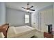 Cozy bedroom with ceiling fan, window, and double doors at 537 Pond Cypress Ct, Auburndale, FL 33823
