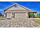 Three-car garage with paver driveway and stone accents at 537 Pond Cypress Ct, Auburndale, FL 33823