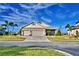 Tan house with three-car garage and landscaped yard at 537 Pond Cypress Ct, Auburndale, FL 33823