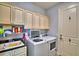 Bright laundry room with washer, dryer, cabinets, and utility sink at 537 Pond Cypress Ct, Auburndale, FL 33823