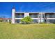 Rear view of condo building showcasing balconies and lawn at 608 Sweet Bay Cir, Winter Haven, FL 33884