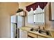 Galley kitchen features white appliances and double sink at 608 Sweet Bay Cir, Winter Haven, FL 33884
