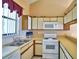 Kitchen with white appliances and wood cabinets at 608 Sweet Bay Cir, Winter Haven, FL 33884