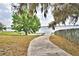 Lake access walkway with a tree and fence at 608 Sweet Bay Cir, Winter Haven, FL 33884