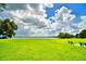 Serene lakefront lawn with lush grass and benches at 608 Sweet Bay Cir, Winter Haven, FL 33884