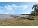 Picturesque lakeside dock with clear water views, surrounded by lush greenery and blue skies at 922 S Lake Reedy Blvd, Frostproof, FL 33843