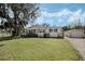 Charming single-story home with a spacious front yard, lush landscaping, and detached garage at 922 S Lake Reedy Blvd, Frostproof, FL 33843