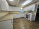 Bright and functional kitchen featuring white cabinets, modern appliances, and stylish wood flooring at 922 S Lake Reedy Blvd, Frostproof, FL 33843