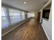 Long sunroom area with sheer curtains and wood floors, leading to main living area at 922 S Lake Reedy Blvd, Frostproof, FL 33843