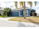 Beautiful blue house with a two-car garage and palm tree at 1005 Corvina Dr, Davenport, FL 33897