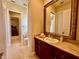 Bright bathroom vanity featuring a large mirror and tile flooring at 1006 W Lake Hamilton Dr, Winter Haven, FL 33881