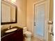 Powder room featuring dark wood vanity, elegant sink fixture, and access door to the exterior at 1006 W Lake Hamilton Dr, Winter Haven, FL 33881
