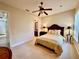 Cozy bedroom featuring a ceiling fan, bedside tables, and a view into the bathroom at 1006 W Lake Hamilton Dr, Winter Haven, FL 33881