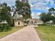 Attractive one-story home with a brick driveway and lush landscaping at 1006 W Lake Hamilton Dr, Winter Haven, FL 33881