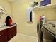 Functional laundry room featuring modern appliances, white shelving, and storage at 1006 W Lake Hamilton Dr, Winter Haven, FL 33881