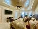 Main bedroom with a tray ceiling, fan, natural light, and large bed with decorative pillows at 1006 W Lake Hamilton Dr, Winter Haven, FL 33881