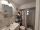 Bathroom with tiled shower, vanity, and storage shelves; decorated with Eiffel Tower patterned curtain at 108 Prospect Ave, Winter Haven, FL 33880