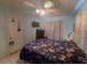 Simple bedroom with blue walls, a window with curtains, tile floor, and a ceiling fan at 108 Prospect Ave, Winter Haven, FL 33880