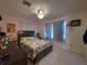 Cozy bedroom with a queen bed, ceiling fan, tile floors, and pink walls at 108 Prospect Ave, Winter Haven, FL 33880