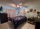 Tranquil bedroom with a ceiling fan, floral bedding, tile flooring and neutral curtains at 108 Prospect Ave, Winter Haven, FL 33880