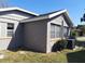 Exterior shot of a home with gray siding, a well-maintained lawn, and an air conditioning unit at 108 Prospect Ave, Winter Haven, FL 33880