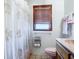 Cozy bathroom featuring a window and shower with a seashell-themed curtain at 1107 Saint Anne Shrine Rd, Lake Wales, FL 33898