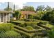 Beautifully landscaped backyard featuring manicured hedges and a charming pergola at 1121 Sunset Dr, Lake Wales, FL 33853