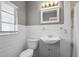 Bathroom features a white vanity, white horizontal paneling, and a window with natural light at 1121 Sunset Dr, Lake Wales, FL 33853