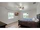 Bedroom with tile floors, a ceiling fan, and a wall-mounted television above a dark wood bed at 1121 Sunset Dr, Lake Wales, FL 33853