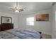 Bedroom with tile floors, a ceiling fan, and a wall-mounted television above a dark wood bed at 1121 Sunset Dr, Lake Wales, FL 33853