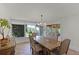 Bright dining area with large windows offering picturesque backyard views and an elegant chandelier at 1121 Sunset Dr, Lake Wales, FL 33853