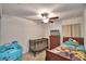 Bedroom with twin bed, crib, ceiling fan, and dresser at 1713 Yellow Trl, Lakeland, FL 33801