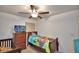 Bedroom with twin bed, crib, ceiling fan, and dresser at 1713 Yellow Trl, Lakeland, FL 33801