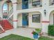 Inviting condo entrance with a pop of color from the red stairs and potted flowers at 2002 Granada Ct # 1, Lake Wales, FL 33898