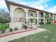Charming two-story condo building featuring a red tile roof, lush landscaping, and private balconies at 2002 Granada Ct # 1, Lake Wales, FL 33898