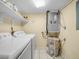 Well-equipped laundry room with a washer, dryer, water heater, and utility shelving at 2002 Granada Ct # 1, Lake Wales, FL 33898