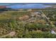 Gorgeous aerial view of land, lush greenery, and large lake on property in sunny neighborhood at 208 Limpkin Ln, Frostproof, FL 33843