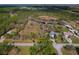 An aerial view of a property featuring mature trees, landscaping, and a pond at 208 Limpkin Ln, Frostproof, FL 33843