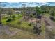 Fenced backyard featuring plenty of space, palm trees, and nearby houses and trees in a rural setting at 208 Limpkin Ln, Frostproof, FL 33843