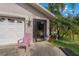 Charming front entrance featuring a garage, ADT security system, and lush tropical landscaping at 208 Limpkin Ln, Frostproof, FL 33843