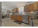Charming kitchen with wooden cabinets, stainless steel dishwasher and laundry rug on tile floors at 208 Limpkin Ln, Frostproof, FL 33843