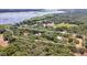 Aerial view of a large property with a house and outbuildings near a lake at 21113 Kissimmee Shores Rd, Lake Wales, FL 33898