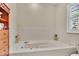 Clean bathroom with a built-in bathtub and window at 21113 Kissimmee Shores Rd, Lake Wales, FL 33898