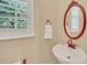 Small bathroom with pedestal sink, oval mirror, and white tile at 21113 Kissimmee Shores Rd, Lake Wales, FL 33898