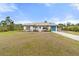 Single-story home with landscaped yard and attached garage at 2330 Park Ave, Indian Lake Estates, FL 33855