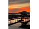 Dock with covered boat lift at sunset over lake at 2400 Crump Rd, Winter Haven, FL 33881