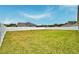 Large, green backyard enclosed by a white fence, providing privacy and space for outdoor activities at 304 Denna Ln, Auburndale, FL 33823